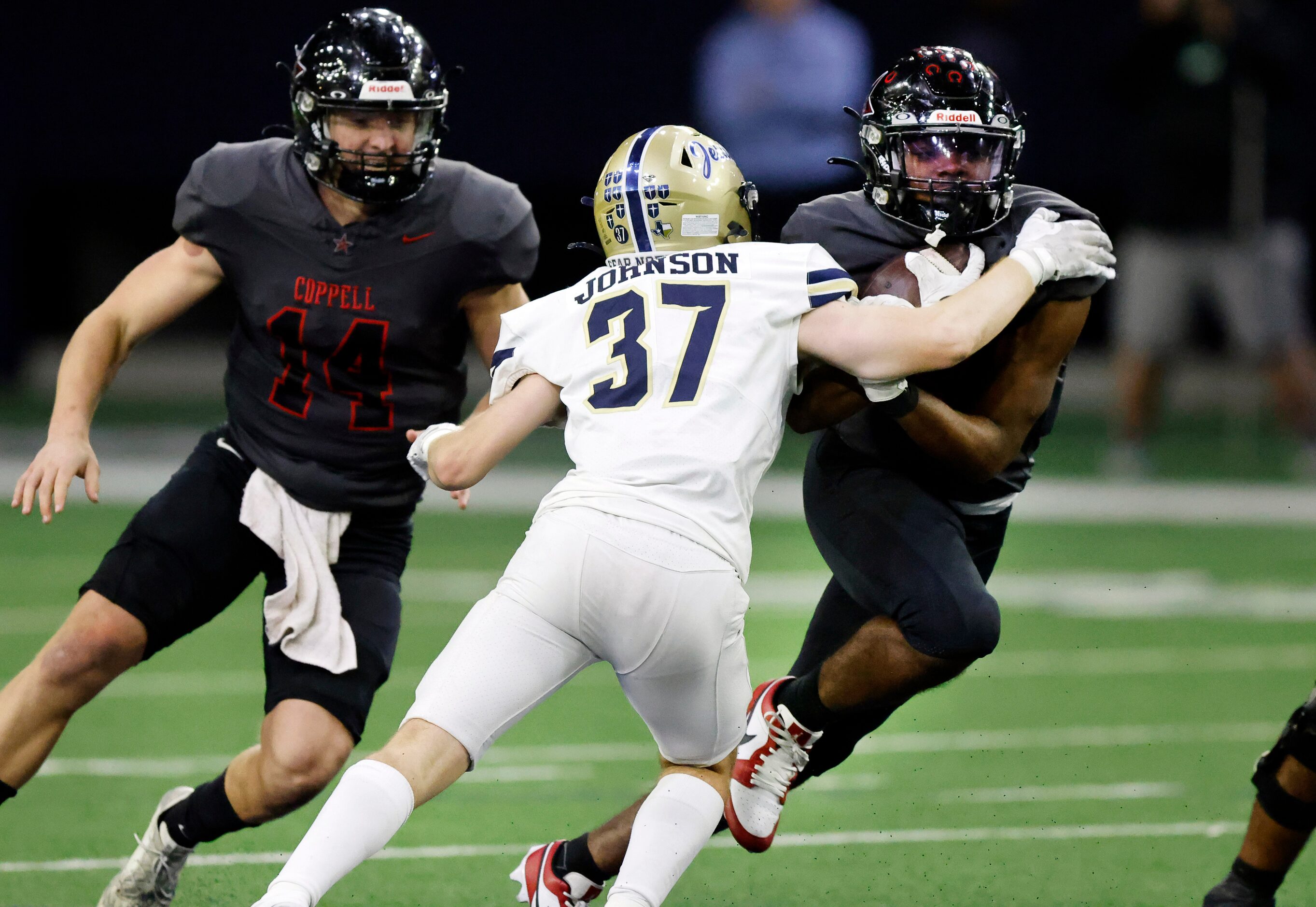 Coppell running back Xavier Mosely (28) runs through Jesuit defensive back Merritt Johnson...