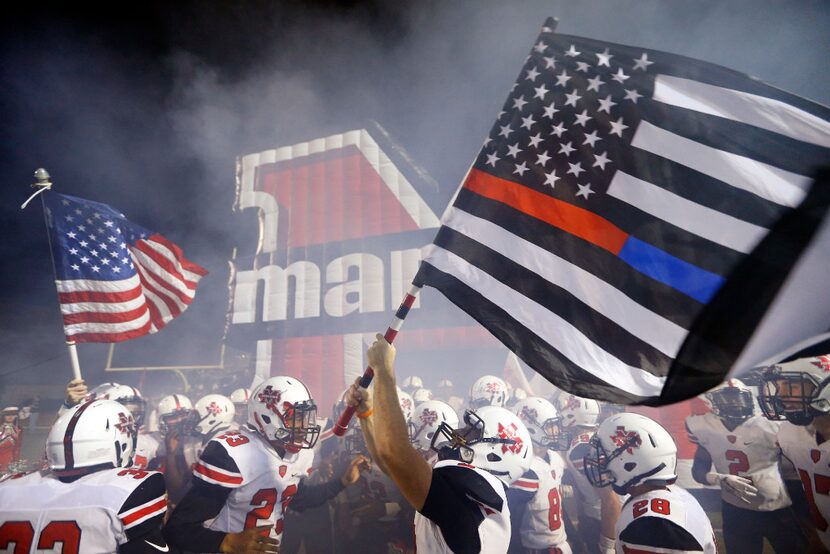 Flower Mound Marcus wide receiver Cooper Anderson (9) waves a first responders colored U.S....