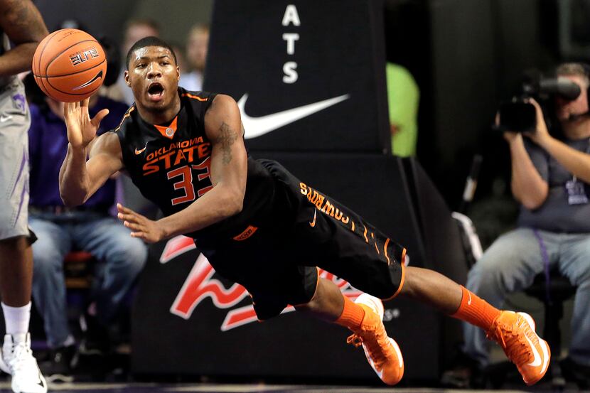 Oklahoma State guard Marcus Smart passes the ball during the first half of an NCAA college...