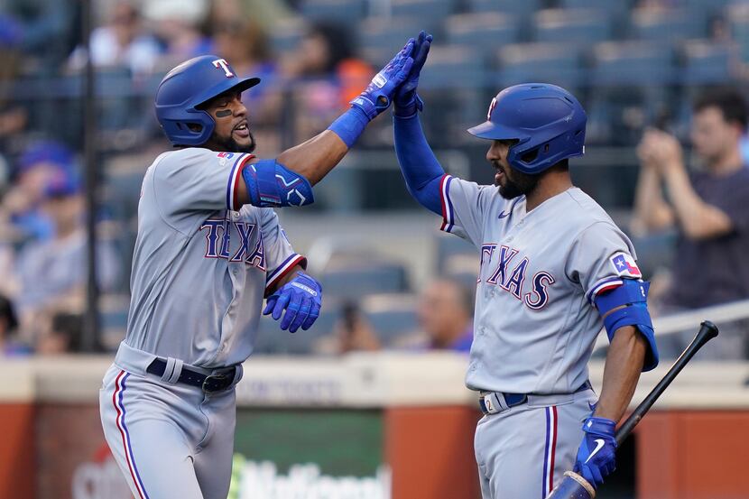Texas Rangers' Leody Taveras, left, celebrates with Marcus Semien, right, after hitting a...