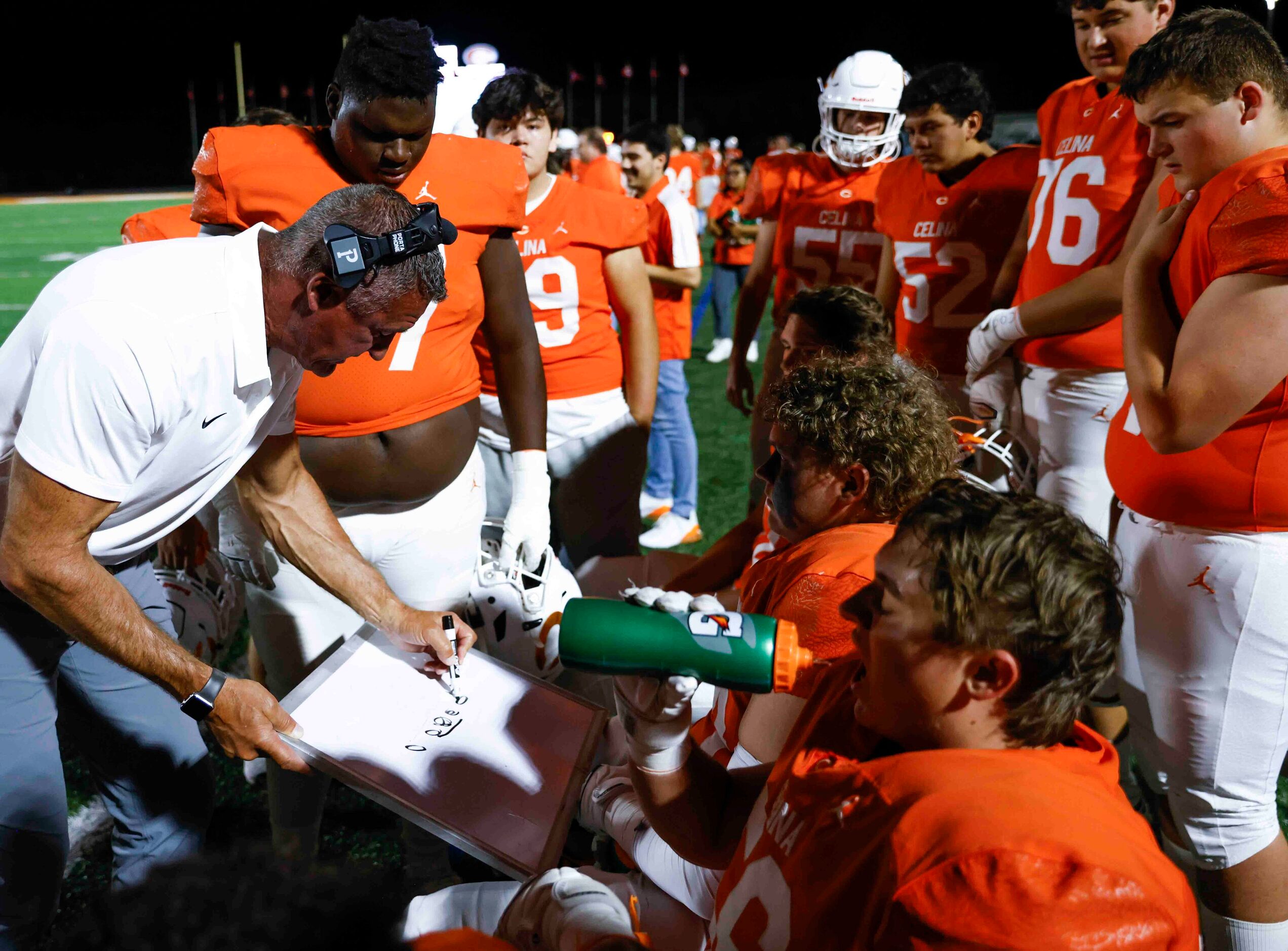 Celina head coach Bill Elliott instructs his team during the first half of a football game...