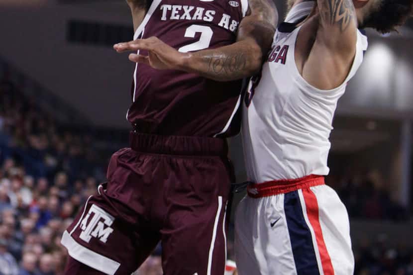 Texas A&M guard TJ Starks, left, shoots while defended by Gonzaga guard Josh Perkins during...