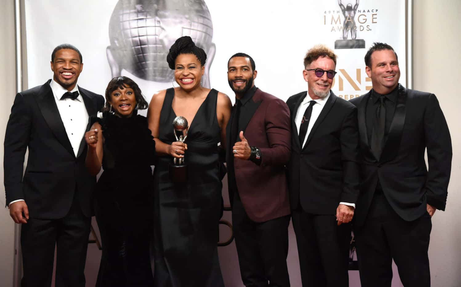 The cast and crew of "Power" pose in the press room with the award for outstanding drama...