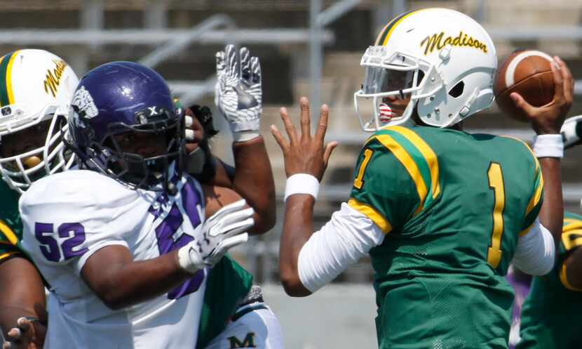 Dallas Madison quarterback Travion Jackson (1) looks to pass as Dallas Lincoln defensive end...