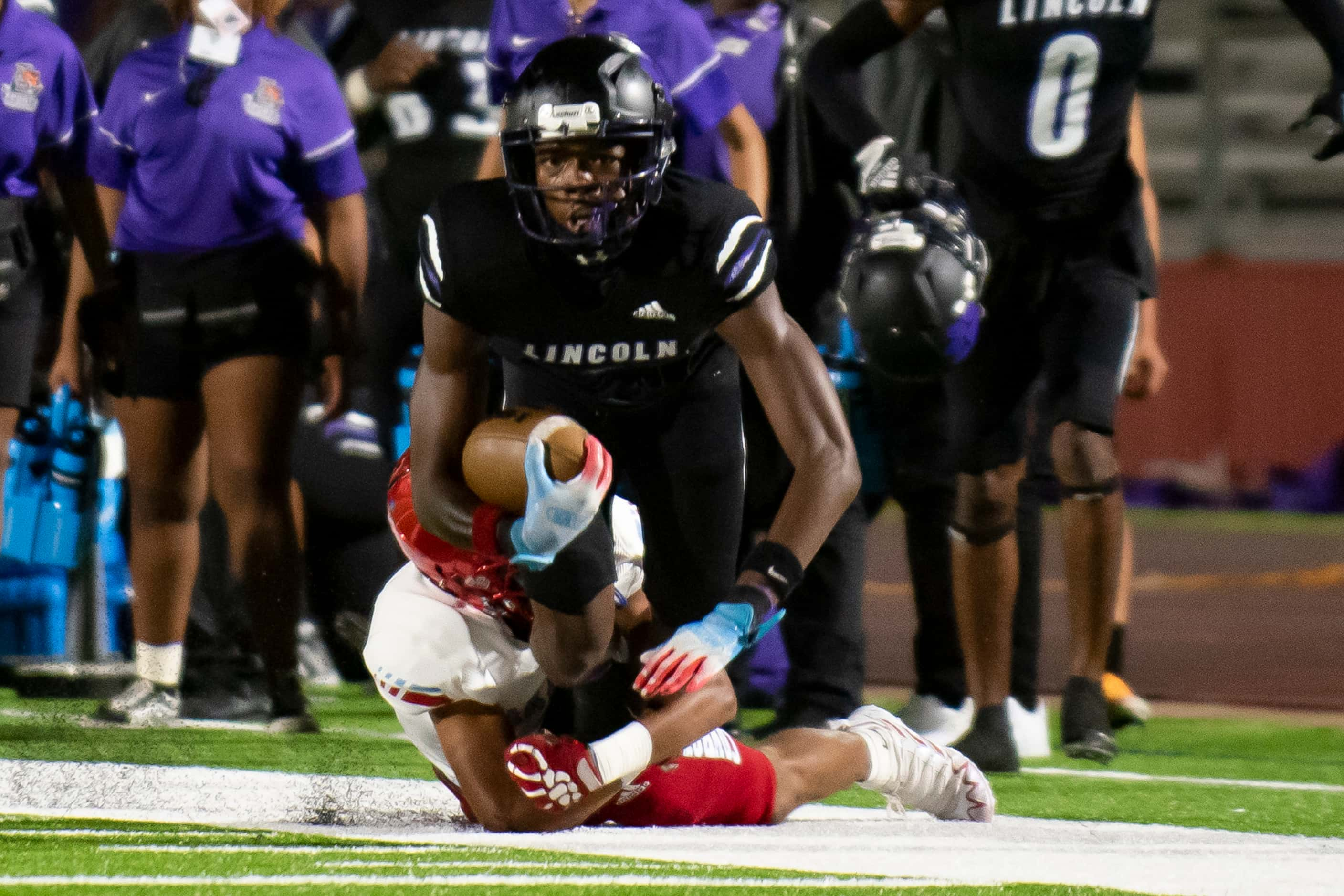 Lincoln senior Jamel Hardy (6) is brought down by a Carter defender during a high school...