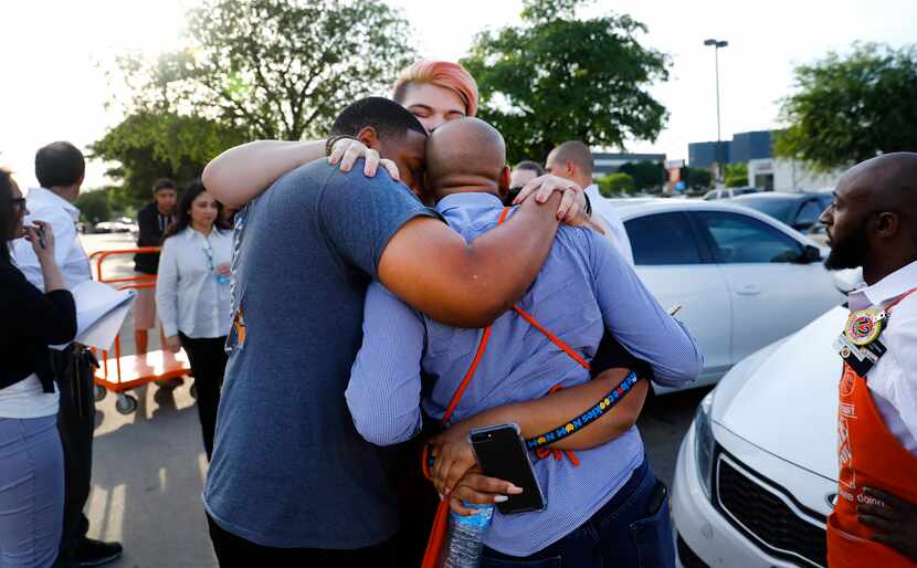 Friends and employees comforted one another outside Home Depot after two officers and a...