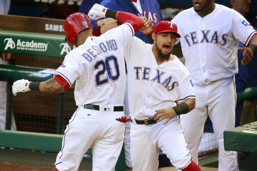 Texas Rangers left fielder Ian Desmond (20) is congratulated on his three-run homer by...