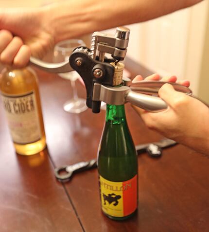 Thomas Berg uses a corkscrew to remove the cork to a gueuze from Brasserie Cantillon.