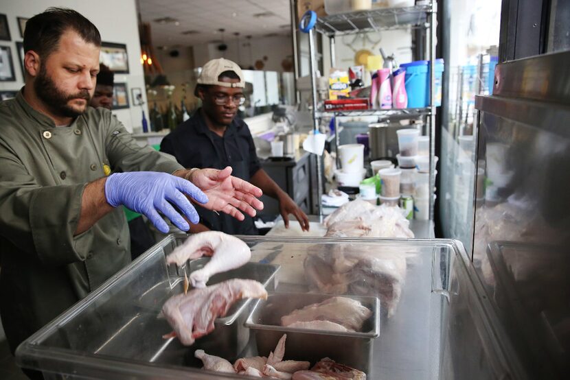 CEO and executive chef Chad Houser places pieces of Redbro chickens from Bonton Farms into a...