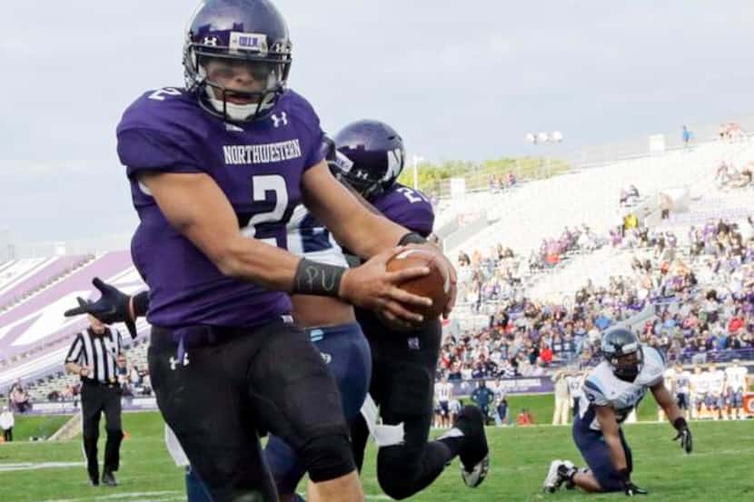 
Northwestern quarterback Kain Colter wears APU for “All Players United” on wrist tape as he...