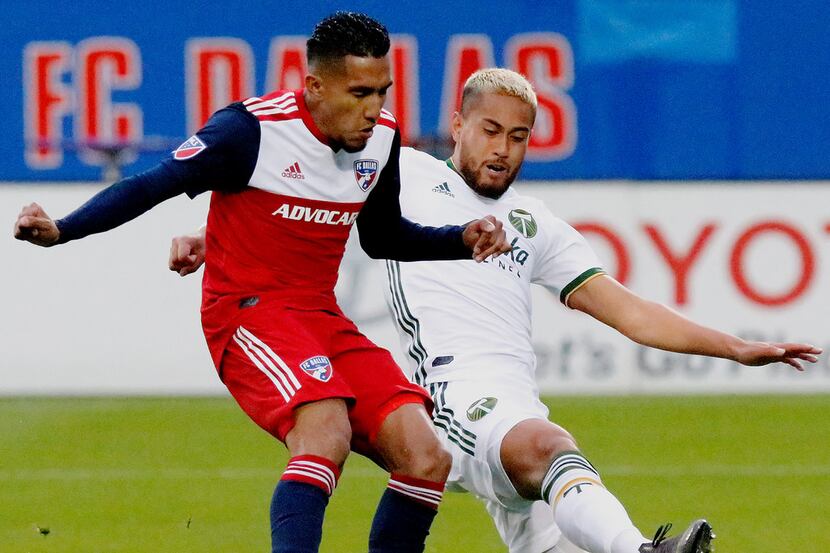 FC Dallas forward Jesus Ferreira, left, shoots for the first goal of the game as he is...