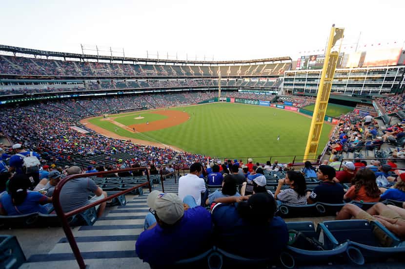 Fans look on at Globe Life Park during a baseball game as the Oakland Athletics play the...