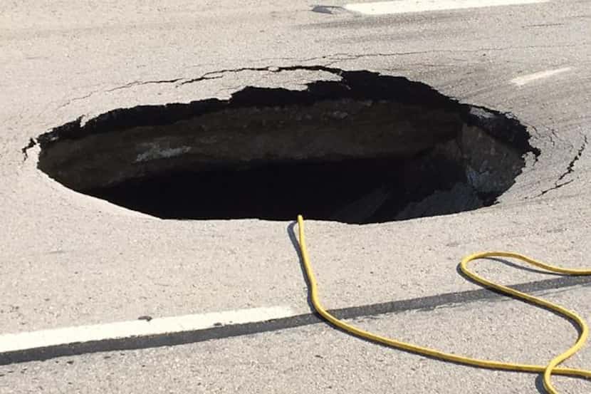 The sinkhole on the westbound service road started as a bump overnight, but has since grown...