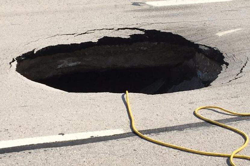 The sinkhole on the westbound service road started as a bump overnight, but has since grown...