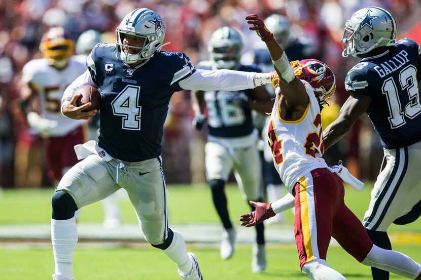 Dallas Cowboys quarterback Dak Prescott (4) stiff arms Washington Redskins cornerback Josh...