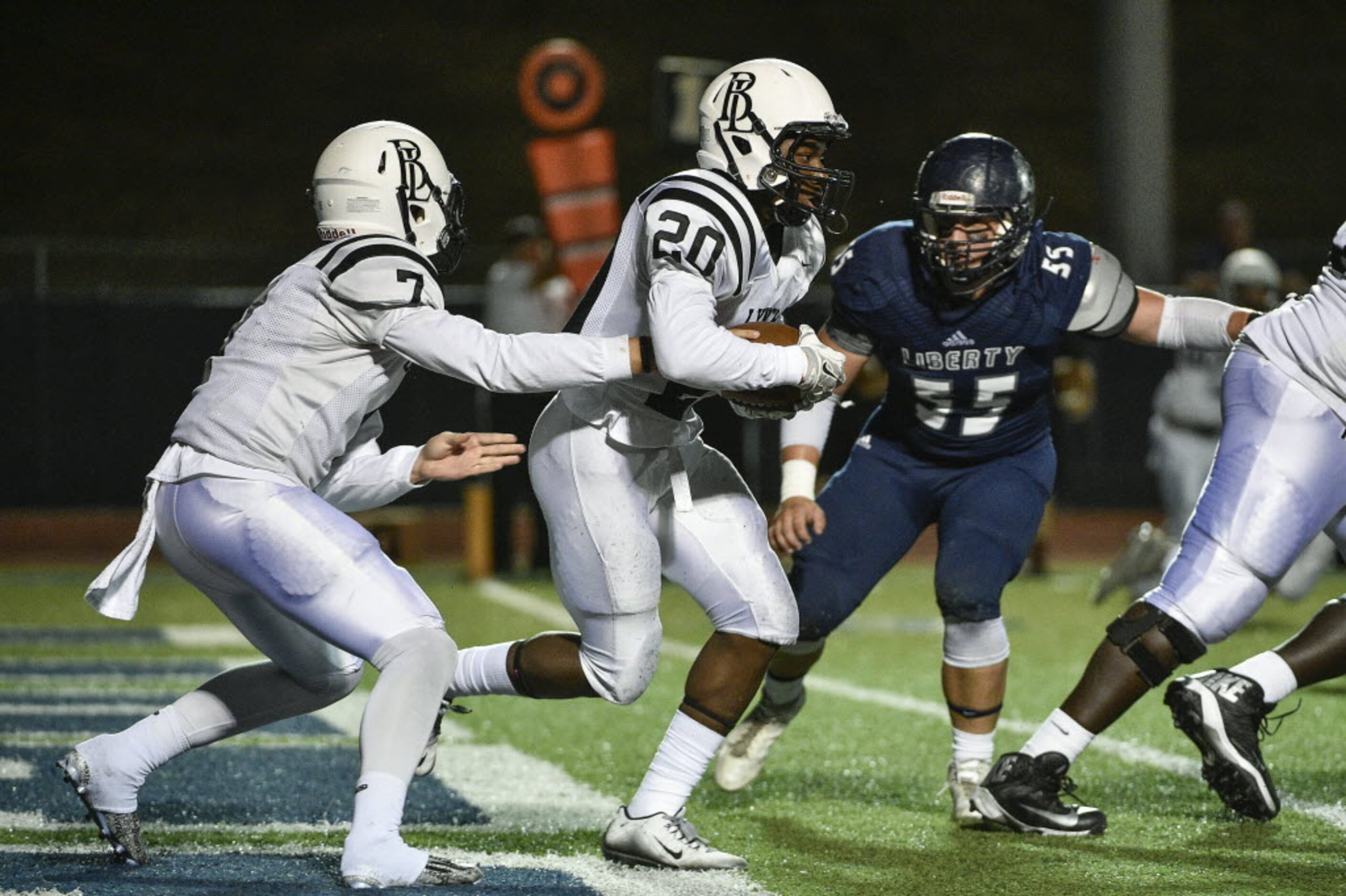 Bishop Lynch running back Jermaine Mask (20) takes a handoff from quarterback Tristan Smith...