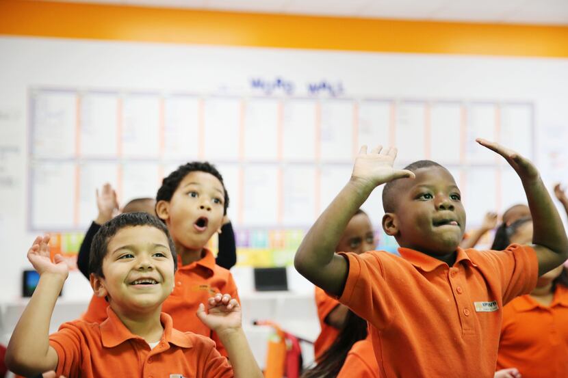 (From left) Pablo Tapia, 5, DaVion Hawkins-Cooper, 5, and Traeveyon Douglas, 5, dance in the...