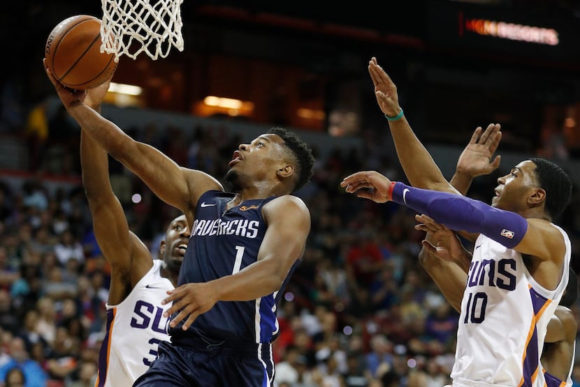 Dallas Mavericks' Dennis Smith Jr., second from left, shoots around Phoenix Suns' Davon...
