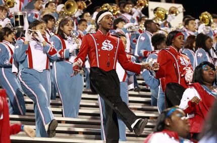 The Skyline High band plays and dances in the stands during a high school football playoff...