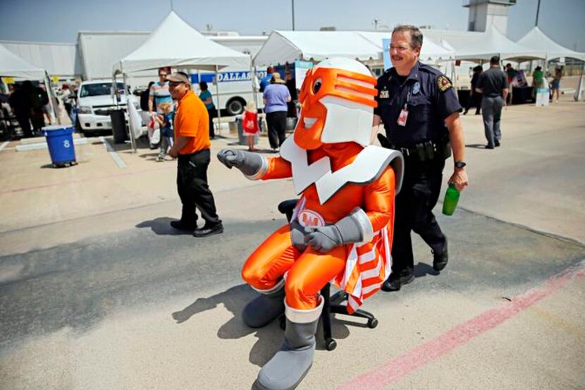 
Dallas police Officer  Scott Young helps wheel a Whataburger mascot, played by Deonté...