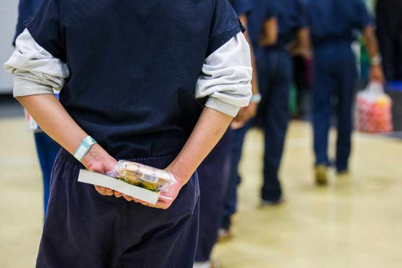 A juvenile inmate held a book and a snack while lining up to leave a Christmas lunch in...