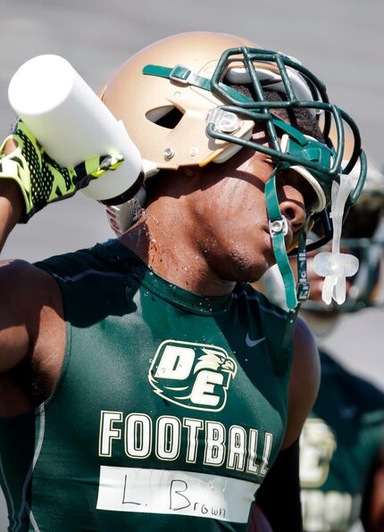 DeSoto senior running back Ladarren Brown uses a water bottle to cool off during the team's...