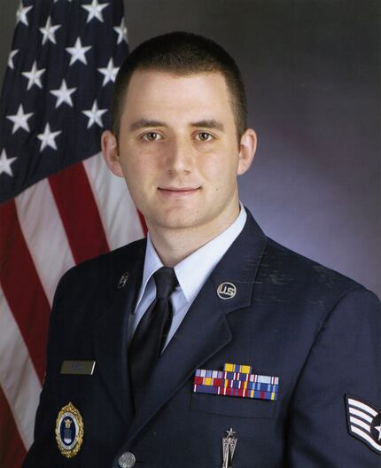 Jeremy Fusco poses for a photo wearing his Air Force uniform covered in various badges.
