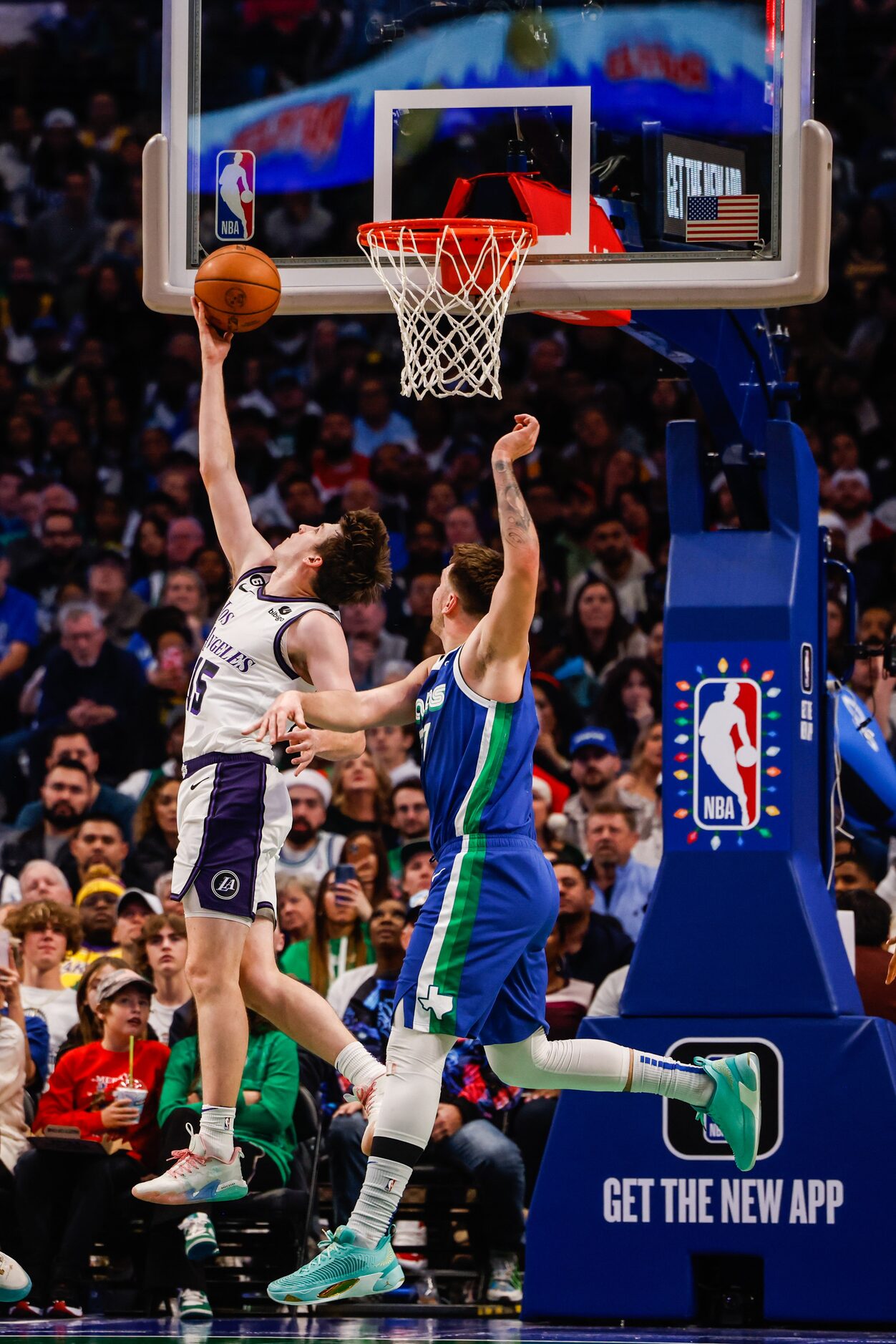 Los Angeles Lakers guard Austin Reaves (15) goes for a shot as Dallas Mavericks guard Luka...