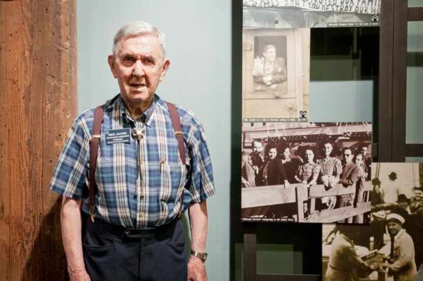 
Mike Jacobs poses next to a photo of himself in an exhibit at the Dallas Holocaust...