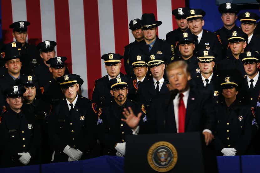 Police officers look on as President Donald Trump speaks at Suffolk Community College on...
