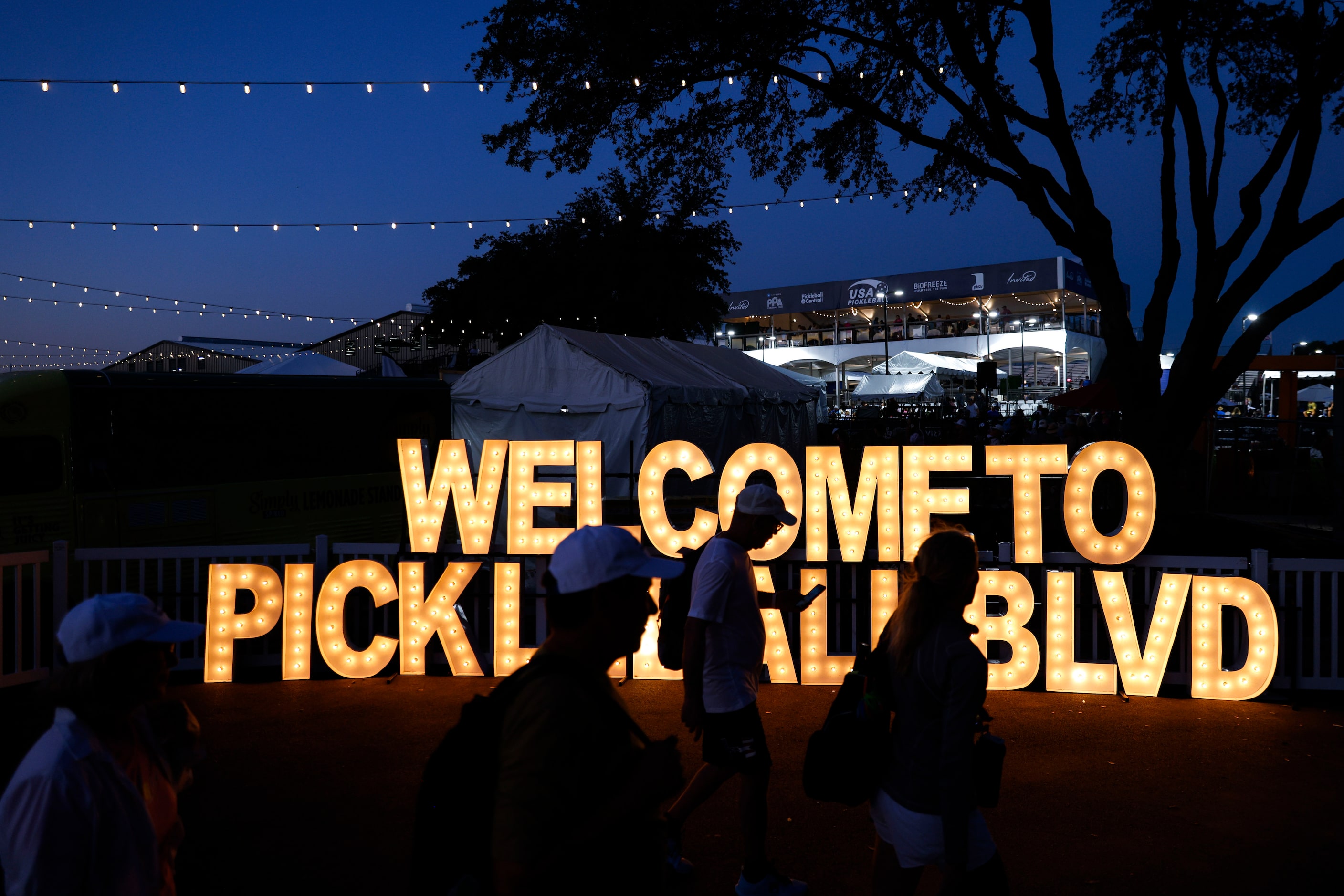 Crowd pass by the main entrance decor of USA Pickleballl National Championship on Tuesday,...