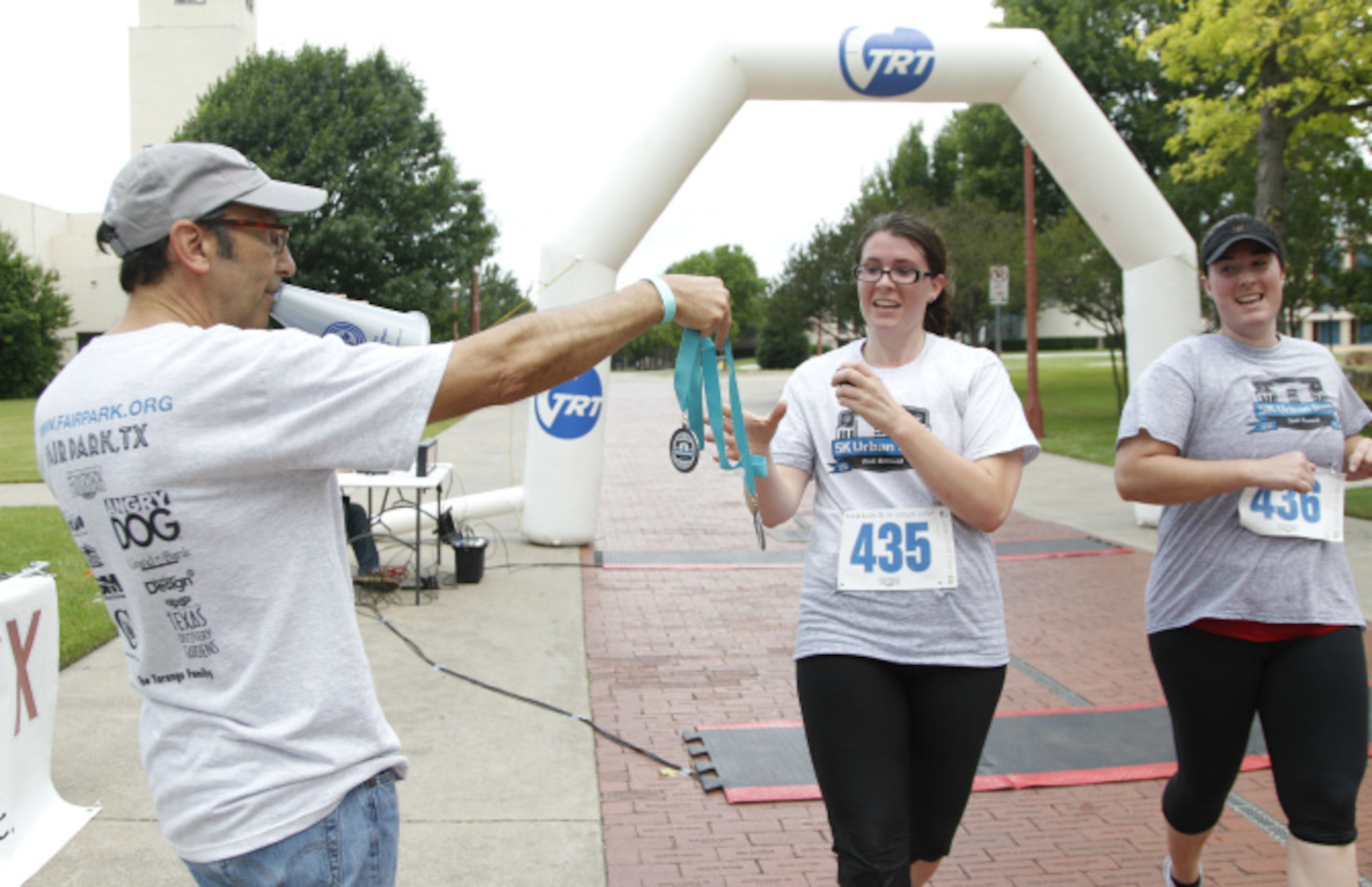 Margeaux Makey grabs her award as she crosses the finish line with her sister Morgan Makey...