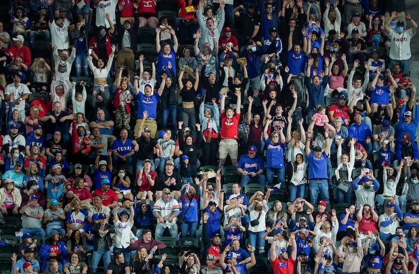 Texas Rangers fans do the wave during the eighth inning against the Baltimore Orioles at...