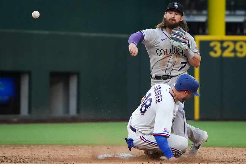 Texas Rangers catcher Mitch Garver (18) slides into Colorado Rockies second baseman Brendan...