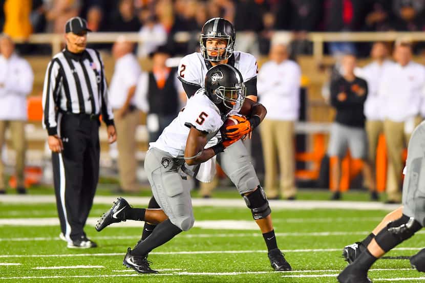 LUBBOCK, TX - SEPTEMBER 30: Mason Rudolph #2 of the Oklahoma State Cowboys hands the ball...