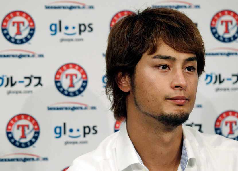 Texas Rangers pitcher Yu Darvish, of Japan, listens to a question during a news conference...