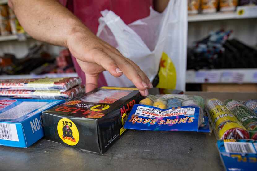 Brock Rodgers bags up fireworks for a customer at his Eagle Fireworks stand on July 2, 2020...