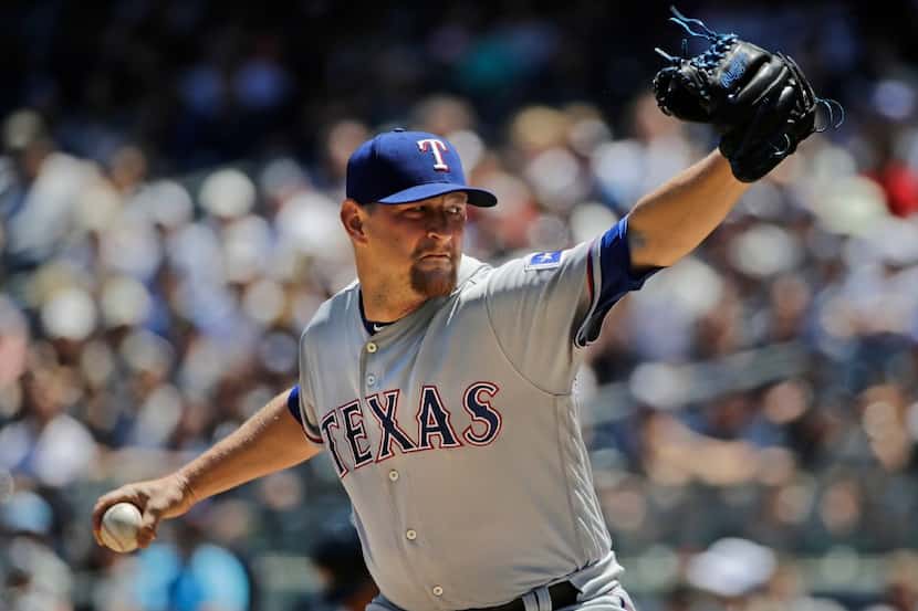 Texas Rangers' Austin Bibens-Dirkx delivers a pitch during the first inning of a baseball...