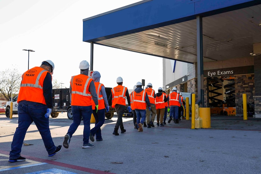 A batch of crews walks towards Sam’s Club on Wednesday, Dec. 14, 2022, a day after a tornado...