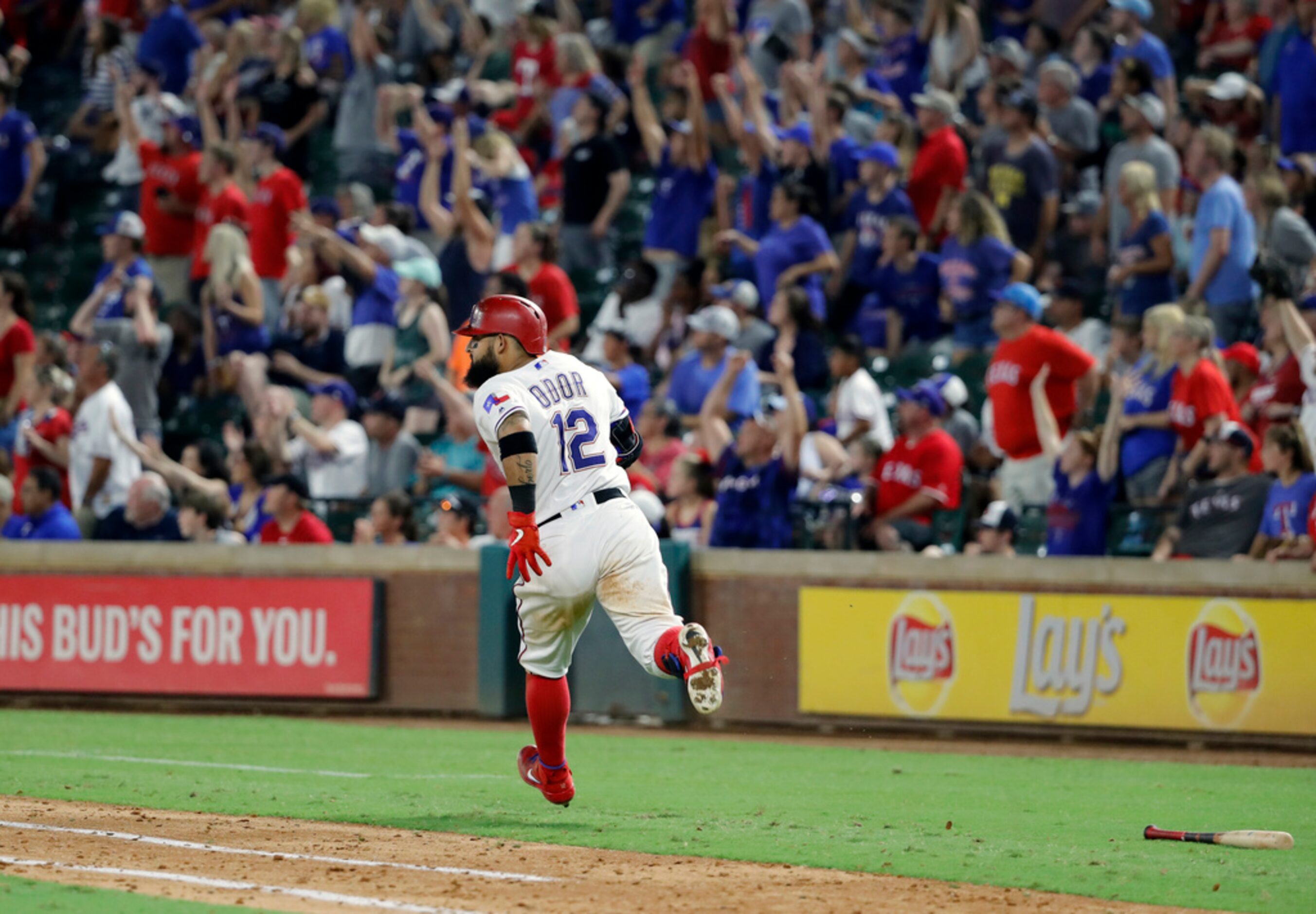 Fans stand and cheer as Texas Rangers' Rougned Odor rounds the bases after hitting a...