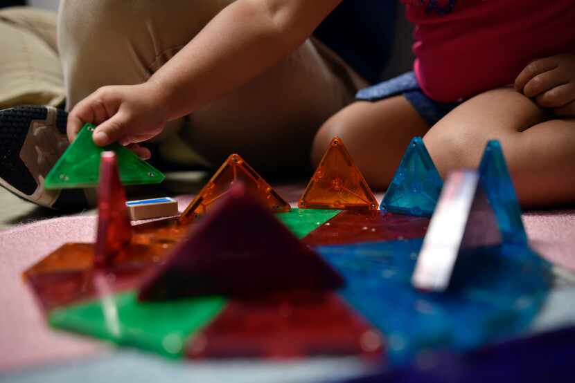 Elizabeth Diaz, 3, uses colored magnets to help her understand colors with her mother...