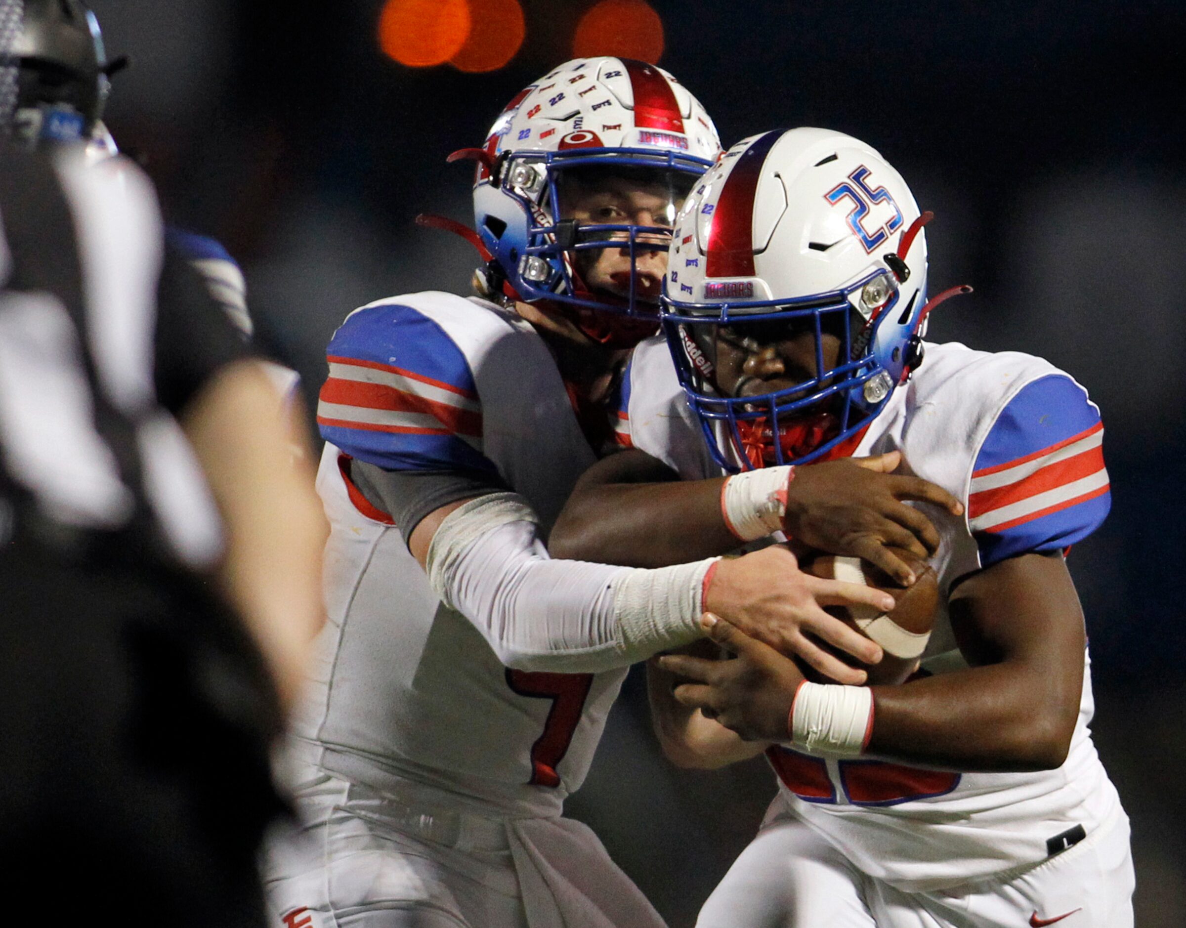 Midlothian Heritage quarterback Carter Rutenbar (9) hands the ball off to Jaguars running...