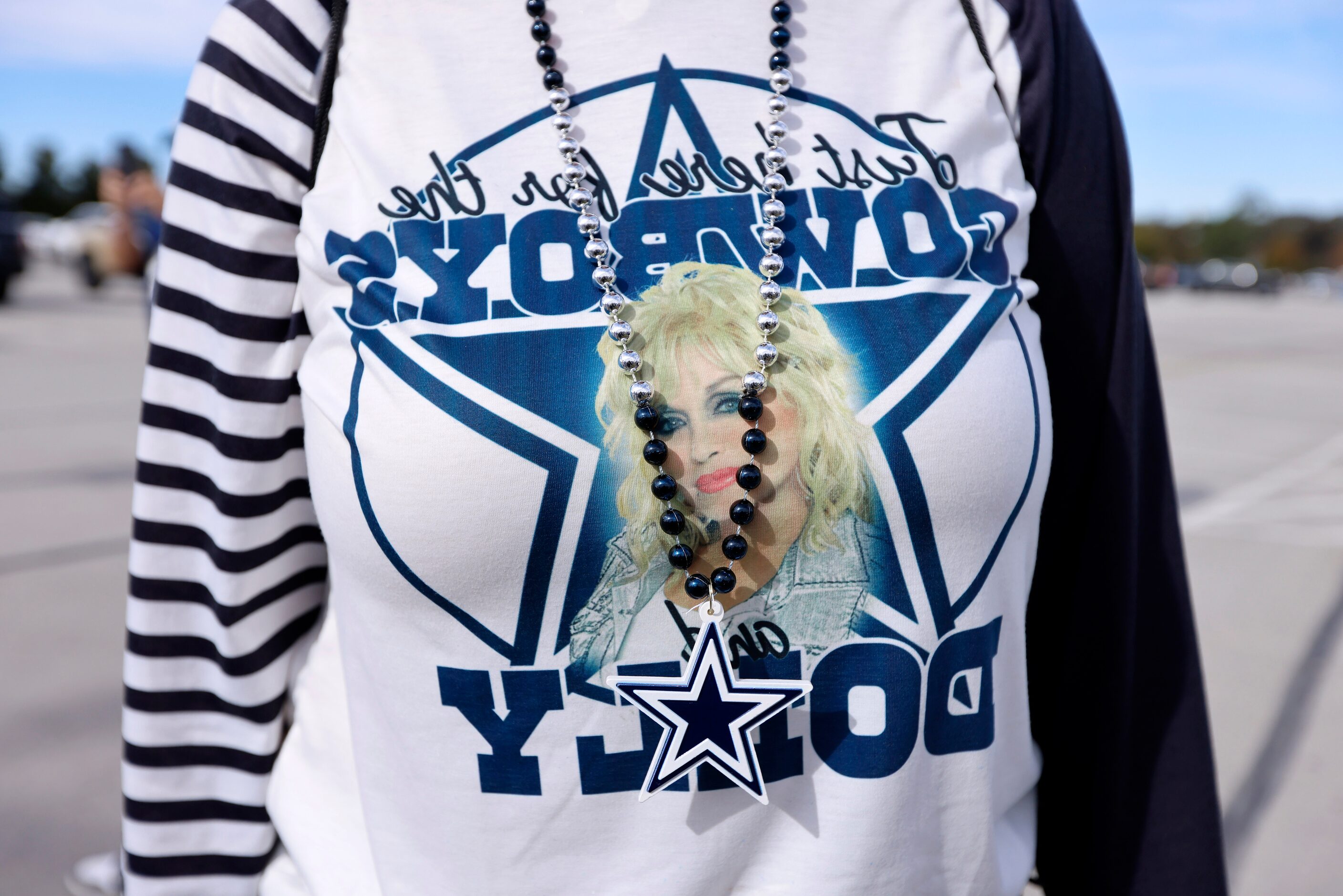 A Dallas Cowboys fan sports a Dolly Parton shirt as she arrives for the Thanksgiving Day...