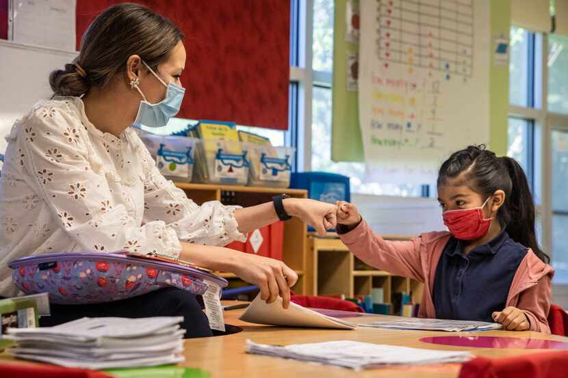 Kindergarten teacher Michelle Davis gives a fist bump to Angelique Luciano, 6, after...