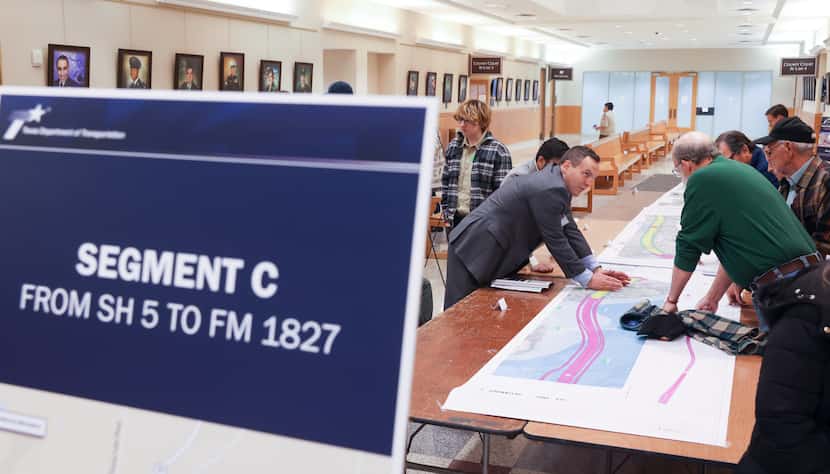 Gordon O’Neal (right) leans over a map of planned segment “C” for the U.S. 380 bypass, which...