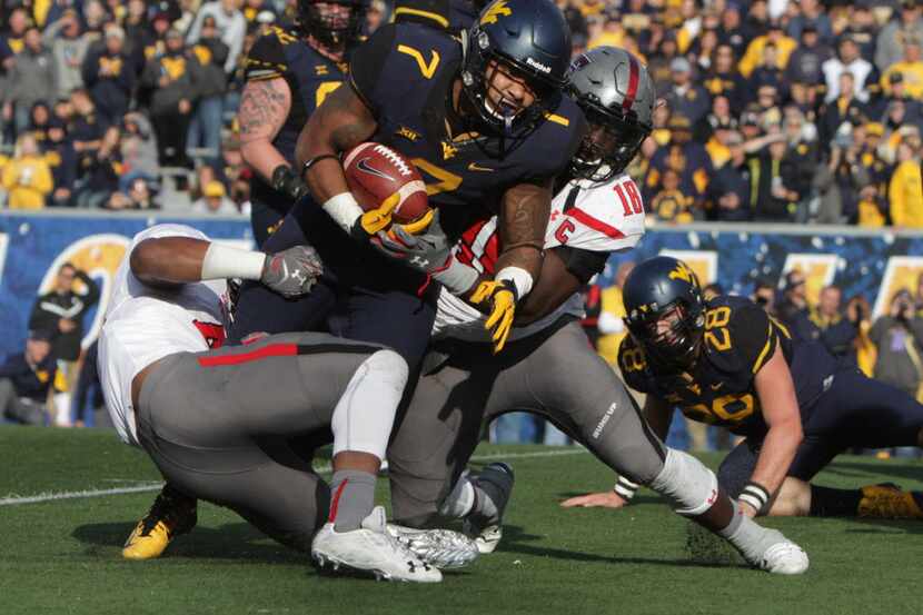 West Virginia running back Rushel Shell (7) is tackled by Texas Tech linebacker Micah Awe...
