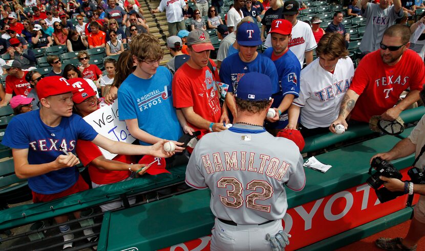 Texas Rangers' Josh Hamilton signs autographs for fans prior to the Rangers baseball game...