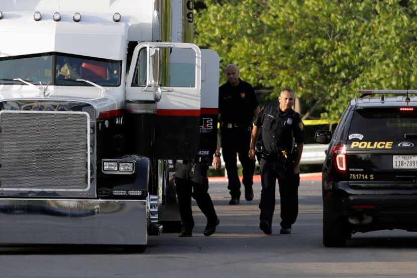 San Antonio police officers investigate the scene where eight people were found dead in a...