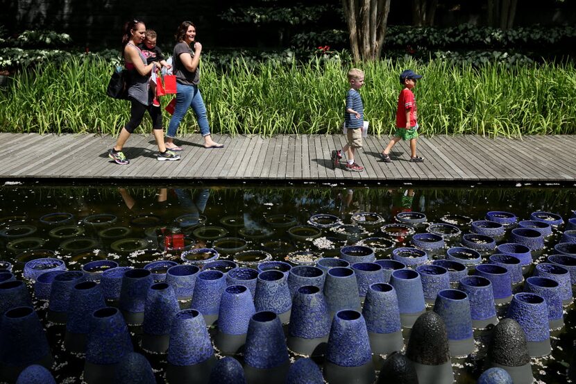 Families walk through the sculpture garden at the Nasher Sculpture Center in downtown Dallas.