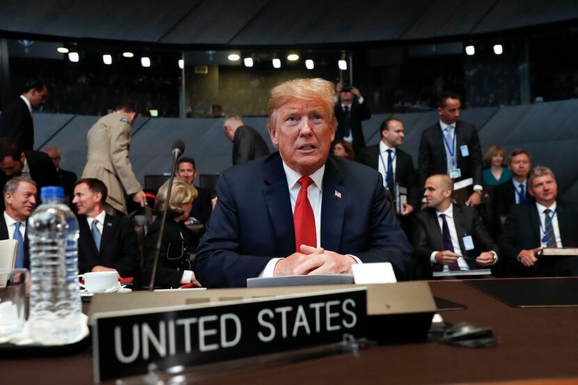 US President Donald Trump takes his seat as he attends the multilateral meeting of the North...